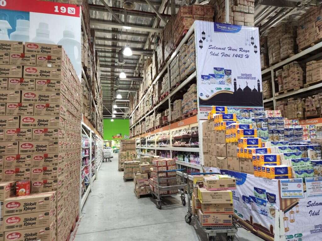 High warehouse shelves stocked with packaged consumer goods and cardboard boxes