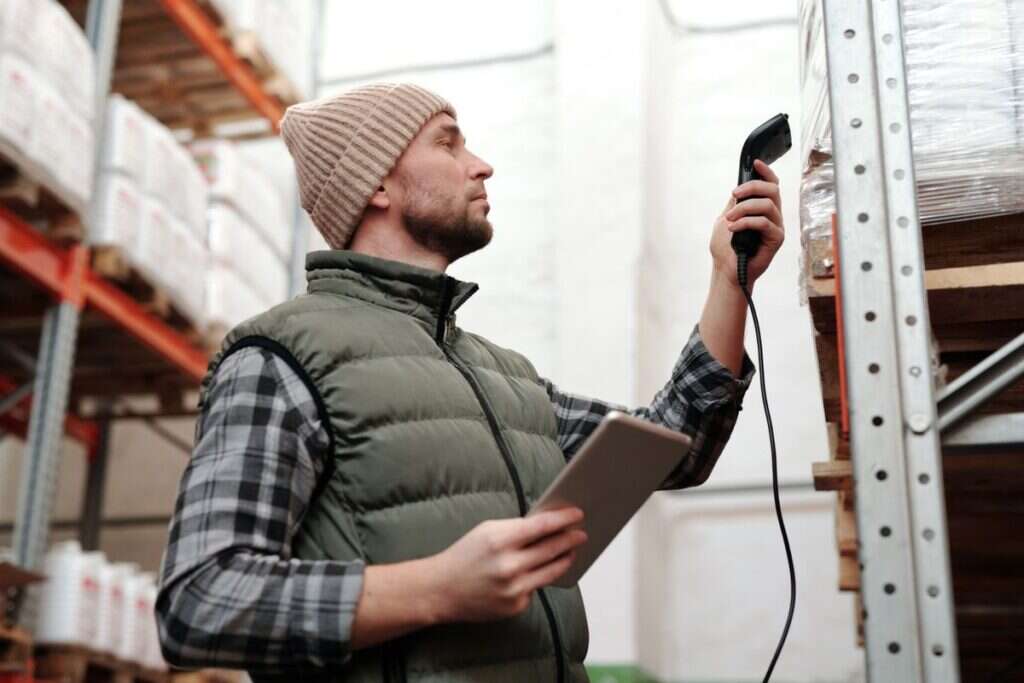 Warehouse staff scanning stock with a handheld scanner and tablet