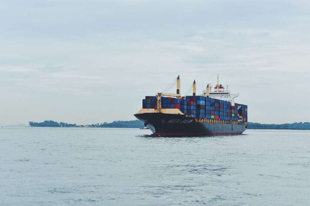 Large cargo ship transporting shipping containers across a calm sea